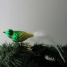 Glasvogel, klein runder Vogel, matt-gold-grün mit weisser Naturfedern